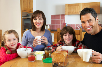 FAMILY EATING BREAKFAST TOGETHER IN KITCHEN © Monkey Business Images | Dreamstime.com